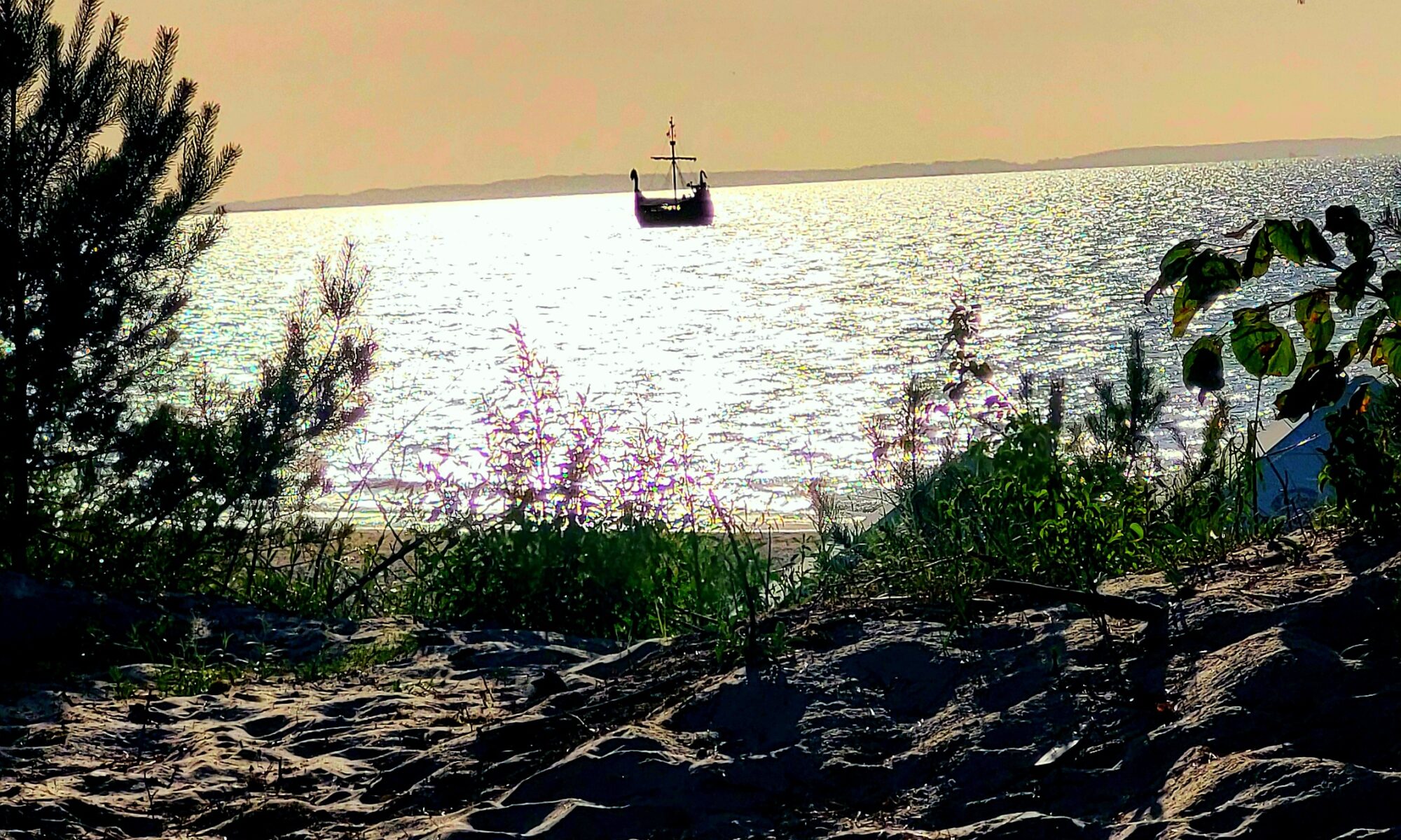 Żaglowiec na horyzoncie podczas zachodu słońca nad Bałtykiem