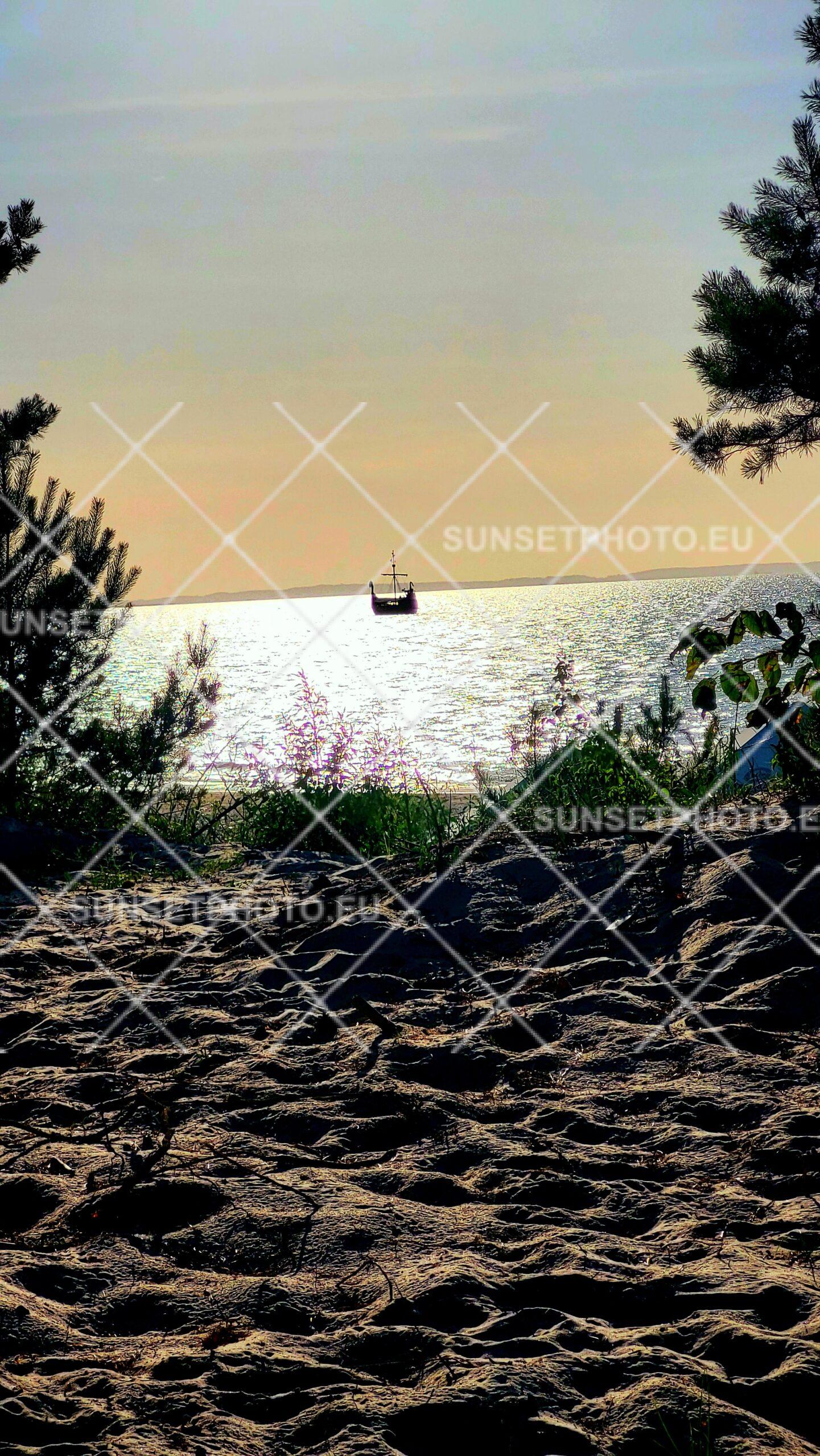 Żaglowiec na horyzoncie podczas zachodu słońca nad Bałtykiem